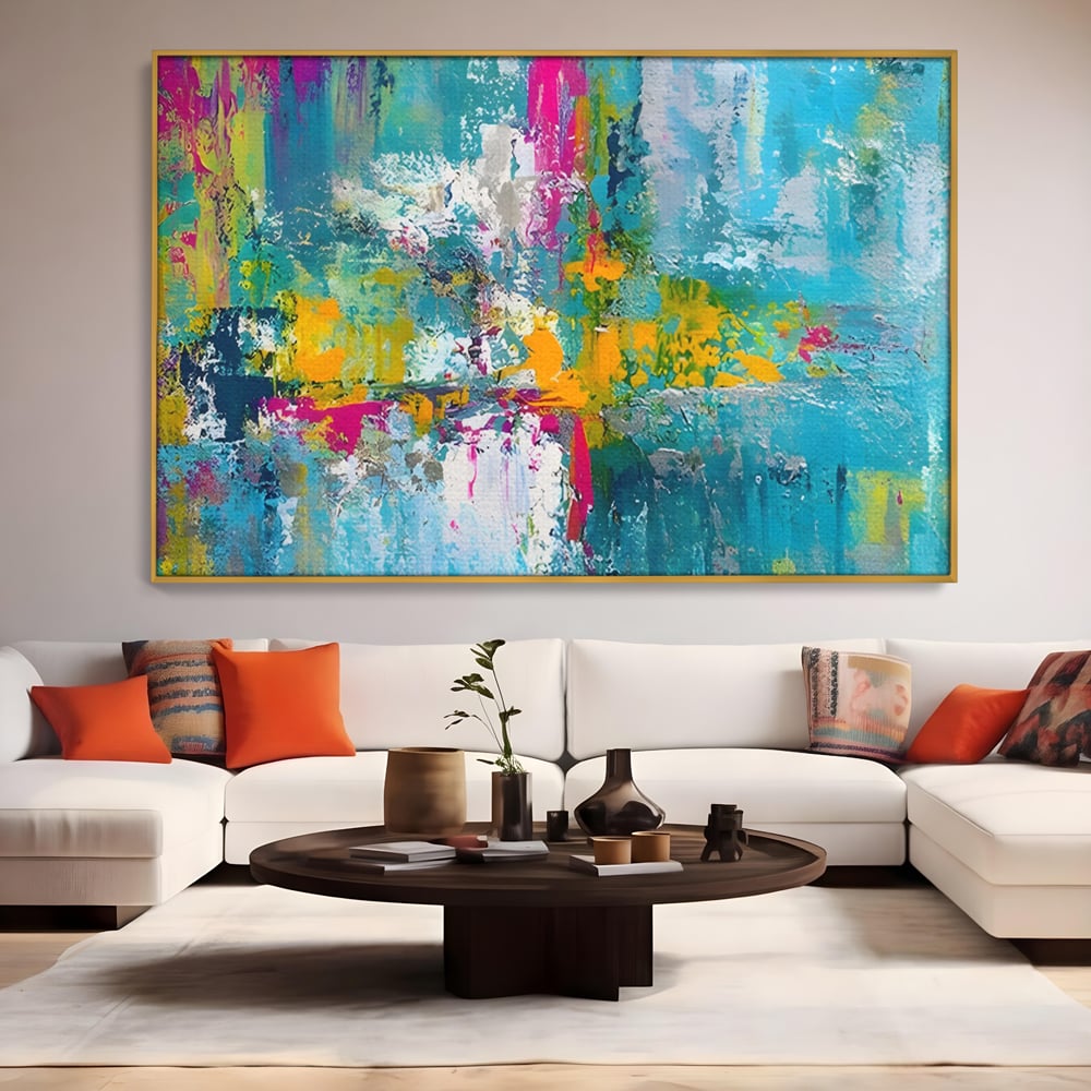 Tablou canvas cu pictura abstracta cu pete albastre si galbene, in rama de aluminiu auriu, pe perete intr-un living