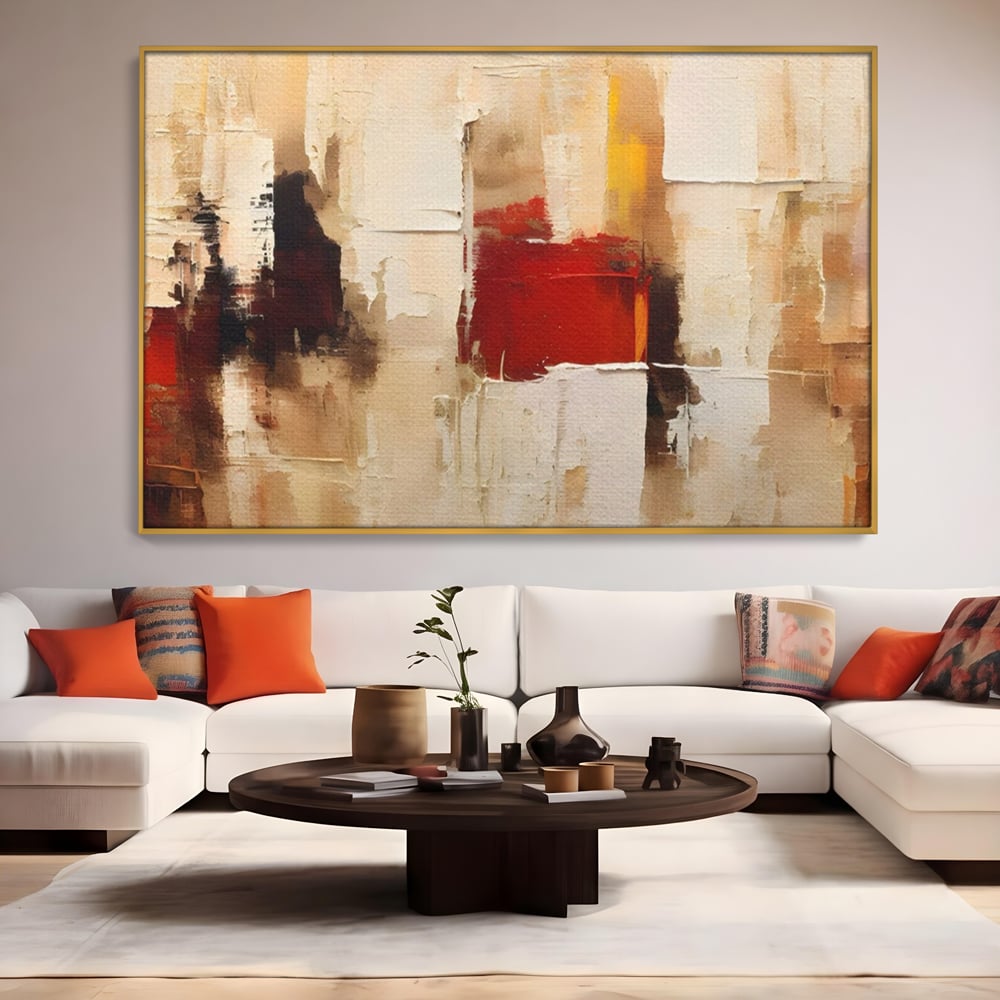 Tablou canvas cu pictura abstracta cu pete de rosu si bej, in rama de aluminiu auriu, pe perete intr-un living