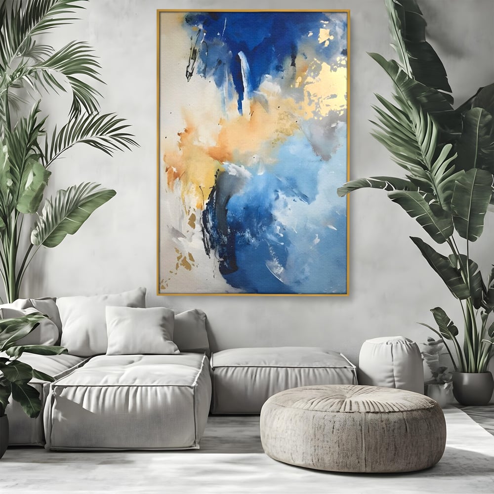 Tablou canvas cu pictura abstracta cu pete albastre si aurii, in rama de aluminiu auriu, pe perete intr-un living