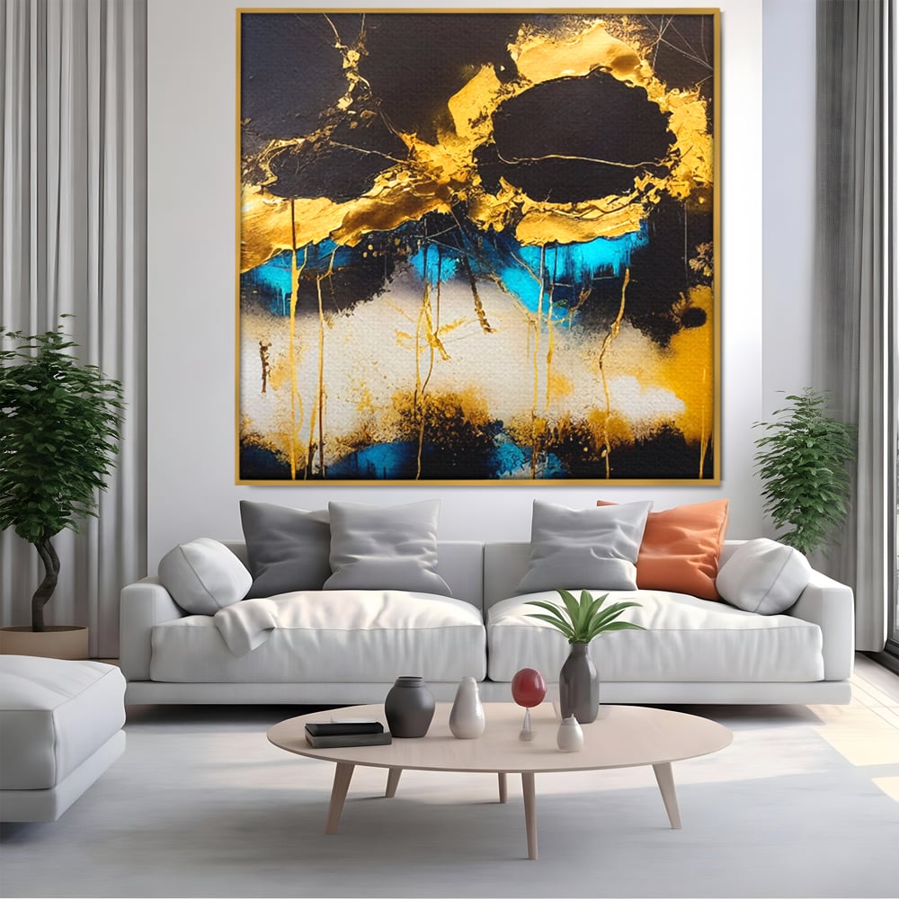 Tablou canvas cu pictura abstracta cu forme aurii si albastre, in rama de aluminiu auriu, pe perete intr-un living