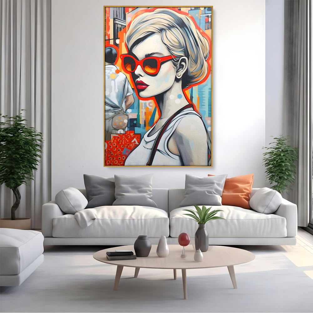 Tablou canvas cu tablou canvas cu portret stilizat de femeie, in rama de aluminiu auriu, pe perete intr-un living
