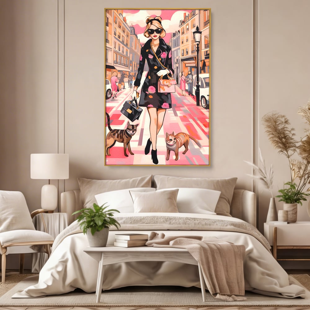 Tablou canvas cu ilustratie fashion cu femeie si pisici, in rama de aluminiu auriu, pe perete intr-un dormitor