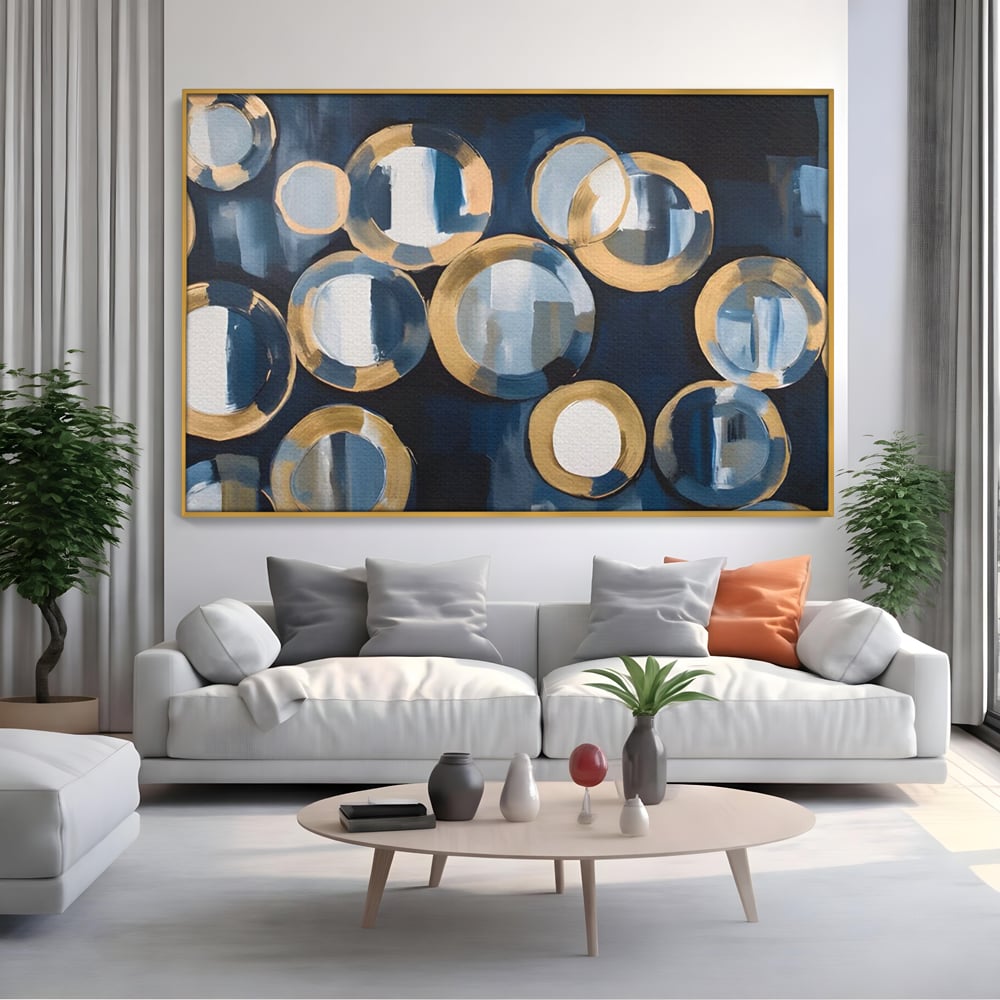 Tablou canvas cu pictura abstracta cu cercuri albastre si aurii, in rama de aluminiu auriu, pe perete intr-un living