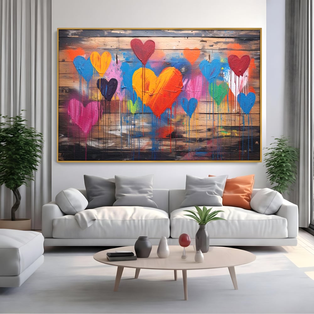 Tablou canvas cu tablou cu inimi colorate pe scanduri, in rama de aluminiu auriu, pe perete intr-un living