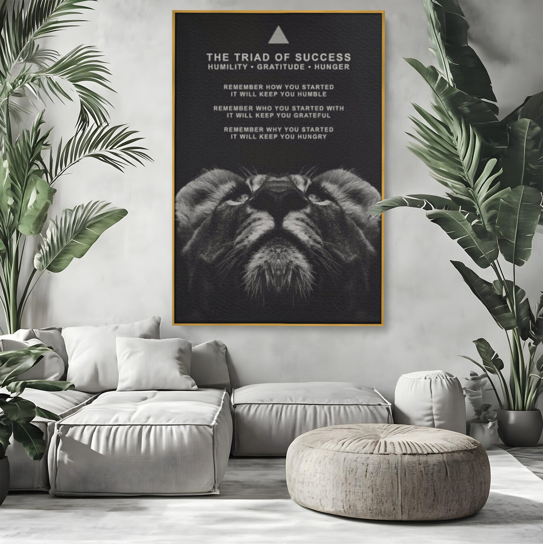 Tablou canvas cu tablou motivational cu cap de leu, in rama de aluminiu auriu, pe perete intr-un living