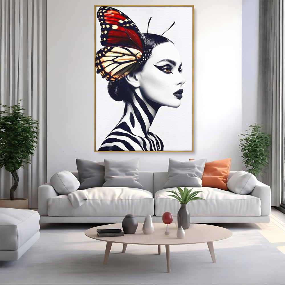 Tablou canvas cu tablou canvas cu femeie si aripa de fluture, in rama de aluminiu auriu, pe perete intr-un living