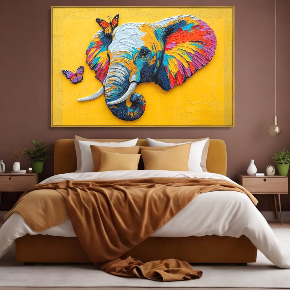 Tablou canvas cu tablou canvas cu elefant colorat si fluturi, in rama de aluminiu auriu, pe perete intr-un dormitor
