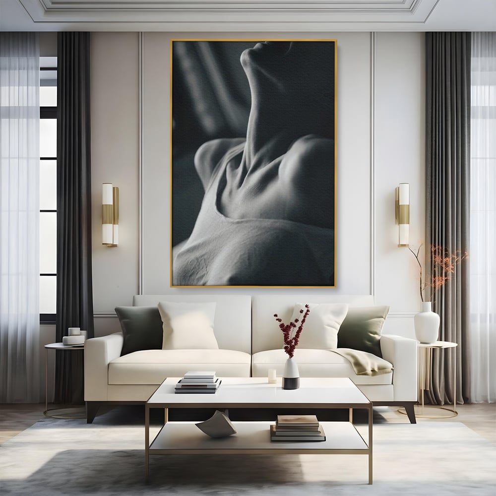Tablou canvas cu fotografie alb-negru cu gatul arcuit al unei femei, in rama de aluminiu auriu, pe perete intr-un living