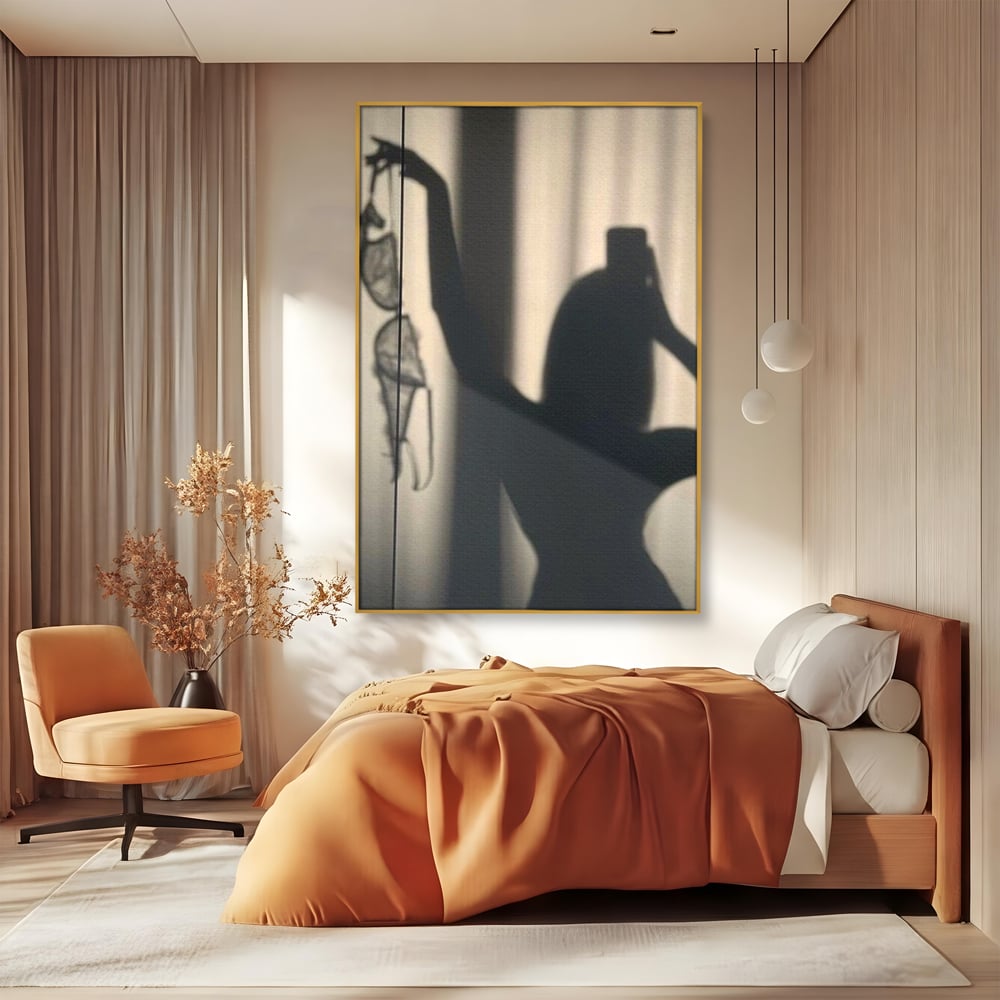 Tablou canvas cu tablou canvas cu silueta si umbra, in rama de aluminiu auriu, pe perete intr-un dormitor