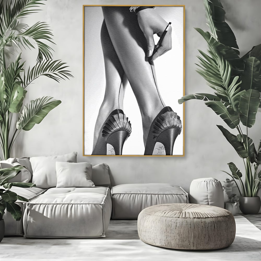 Tablou canvas cu tablou alb-negru picioare dama si pantofi cu toc, in rama de aluminiu auriu, pe perete intr-un living