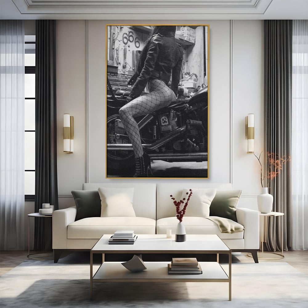 Tablou canvas cu tablou canvas cu femeie pe motocicleta, in rama de aluminiu auriu, pe perete intr-un living