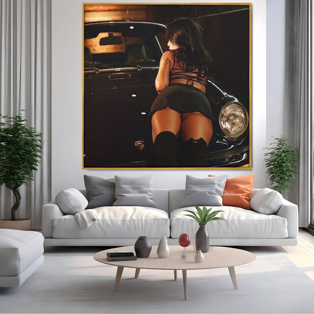 Tablou canvas cu tablou canvas cu femeie pe masina, in rama de aluminiu auriu, pe perete intr-un living