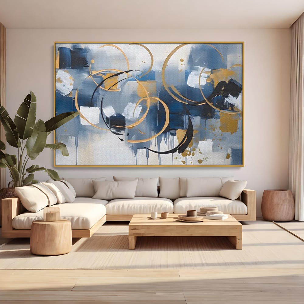 Tablou canvas cu pictura abstracta cu cercuri aurii si albastre, in rama de aluminiu auriu, pe perete intr-un living