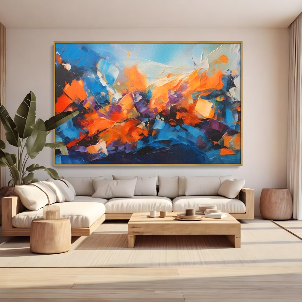 Tablou canvas cu pictura abstracta cu pete portocalii, in rama de aluminiu auriu, pe perete intr-un living