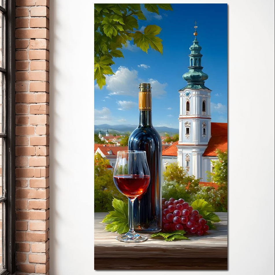 tablou canvas cu o sticla si un pahar de vin rosu si struguri rosii, pe fundal urban cu cladiri si case sub cer senin