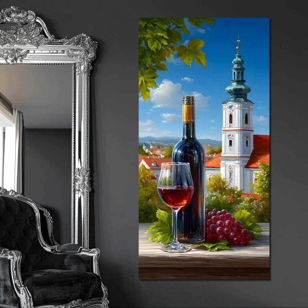 tablou canvas cu o sticla si un pahar de vin rosu si struguri rosii, pe fundal urban cu cladiri si case sub cer senin