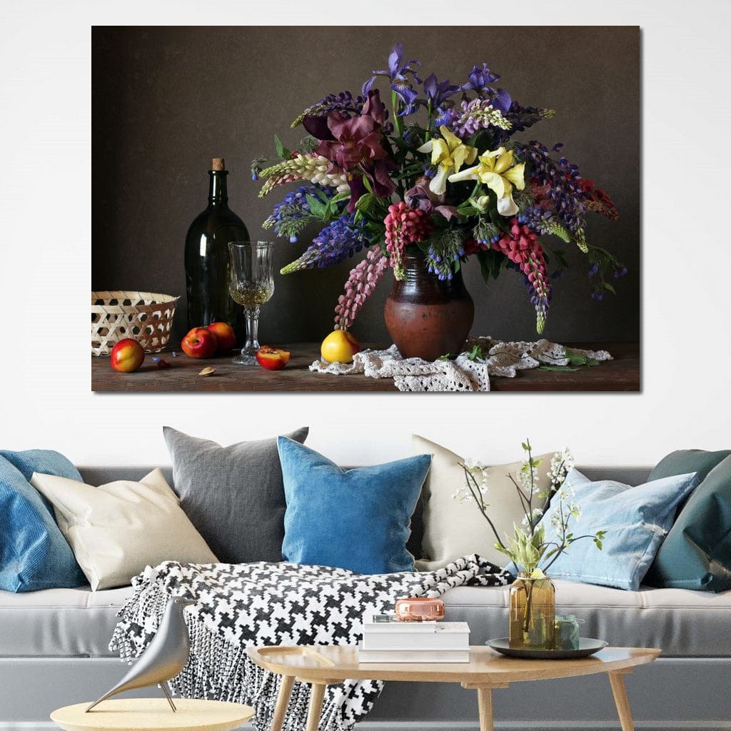 tablou canvas cu o vaza cu flori colorate, pe o masa cu o sticla de vin, un pahar si fructe, intr-un cadru rustic