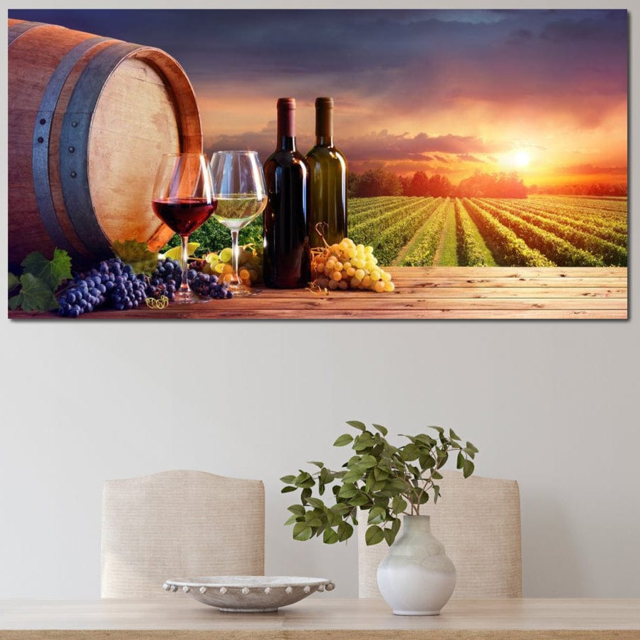 tablou canvas cu un butoi de lemn, doua sticle si doua pahare de vin, alaturi de struguri albi si rosii, pe fundal rustic la apus de soare