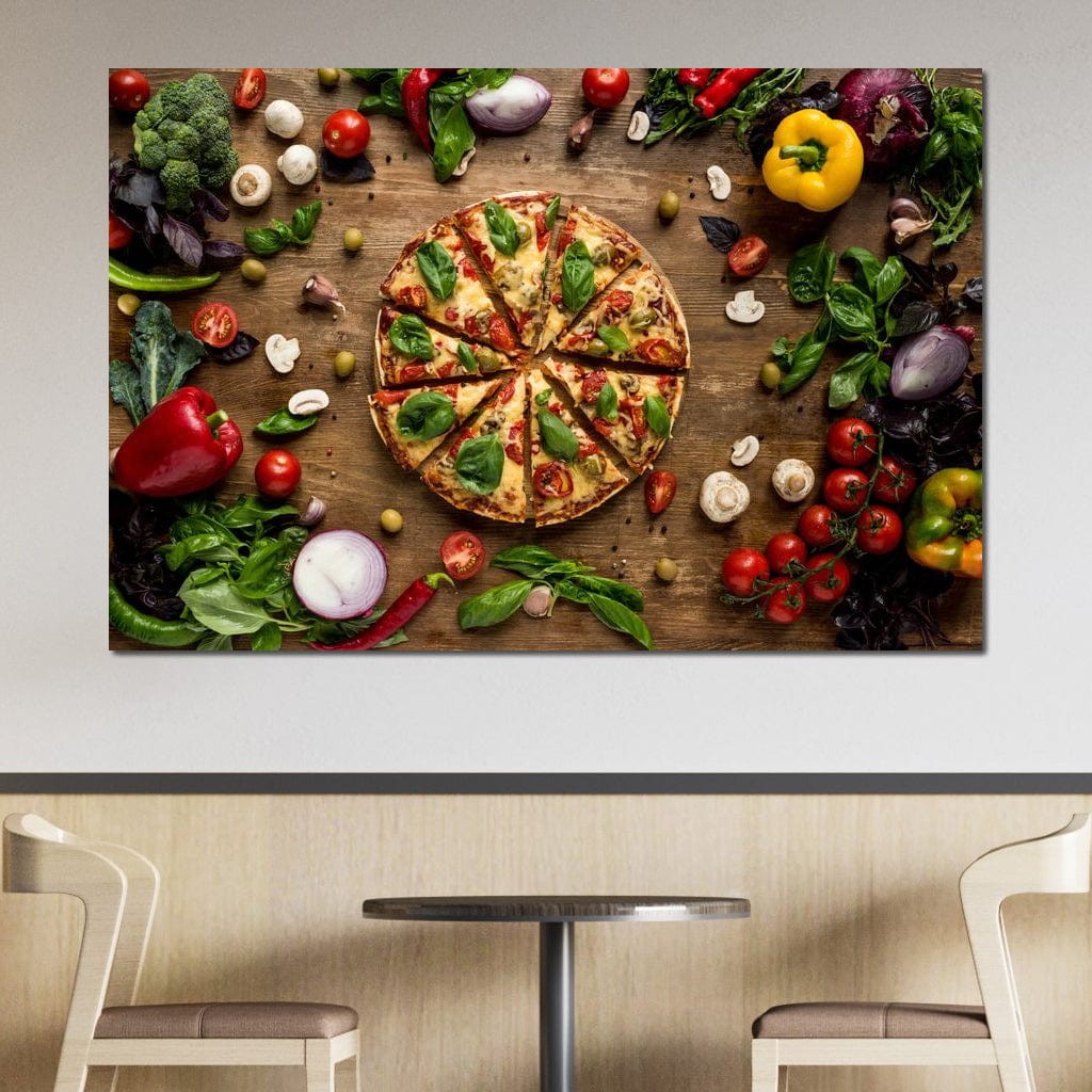 tablou canvas cu o pizza taiata in felii, pe o masa de lemn inconjurata de legume si condimente