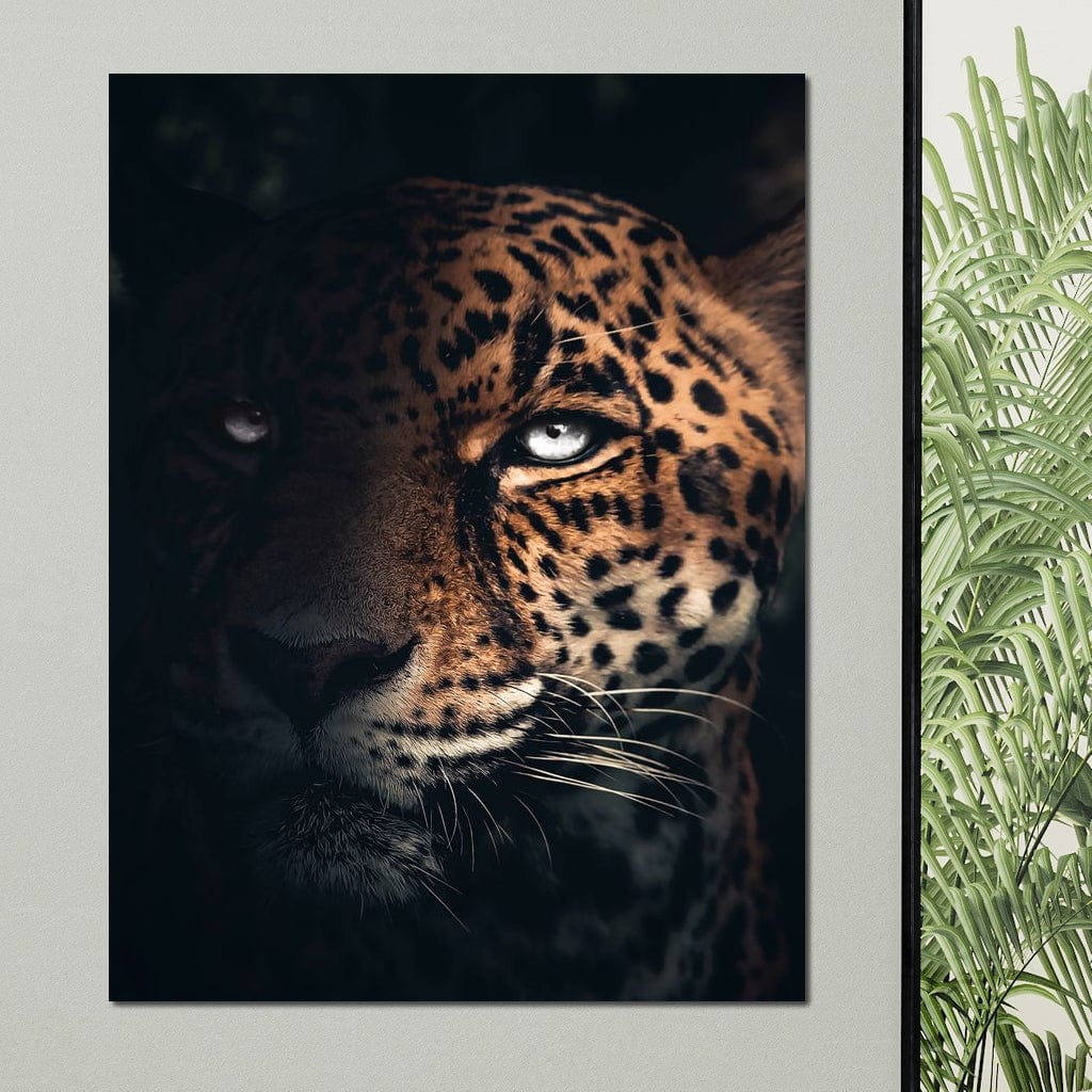 tablou canvas cu un chip de jaguar, cu ochi albastri, surprins in umbra pe fundal intunecat