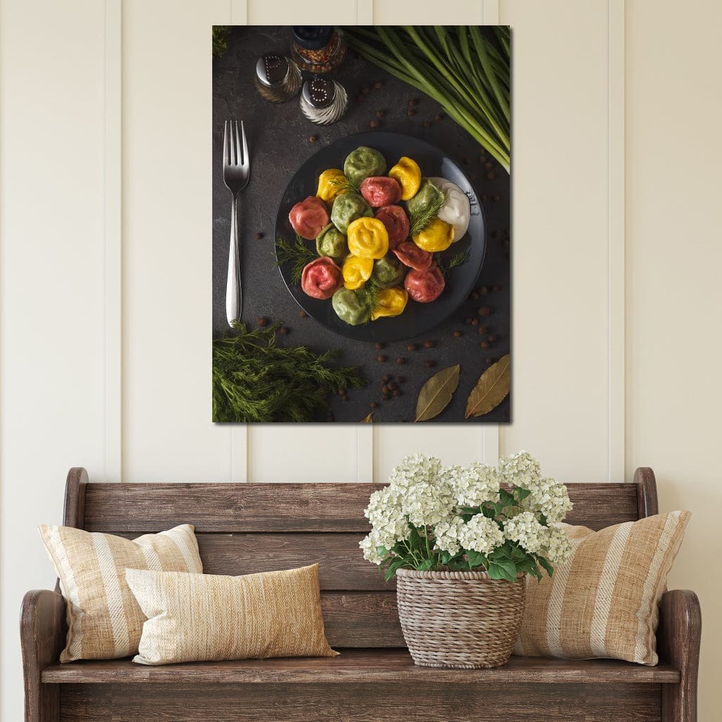 tablou canvas cu o portie de ravioli pe o farfurie neagra, pe o masa cu mirodenii si tacamuri