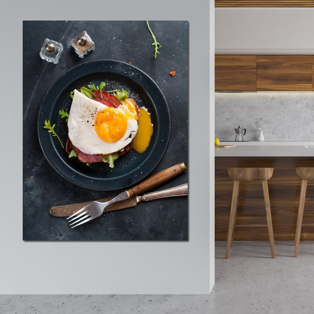 tablou canvas cu o farfurie cu un ou prajit si bacon formand un mic dejun simplu, pe o masa neagra cu tacamuri si condimente