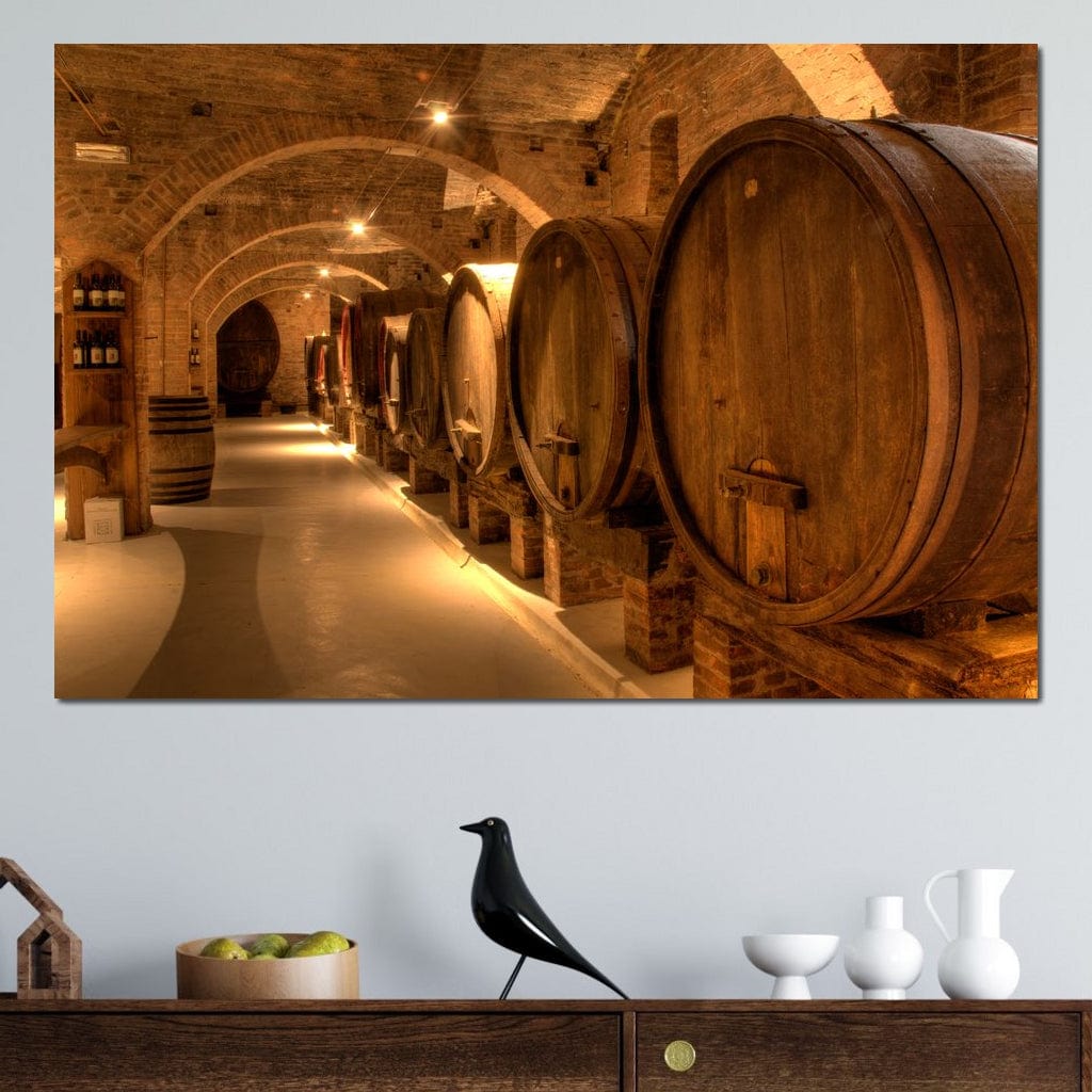 tablou canvas cu butoaie de vin, intr-un subteran in lumina calda, alaturi de sticle de vin si pereti de caramida
