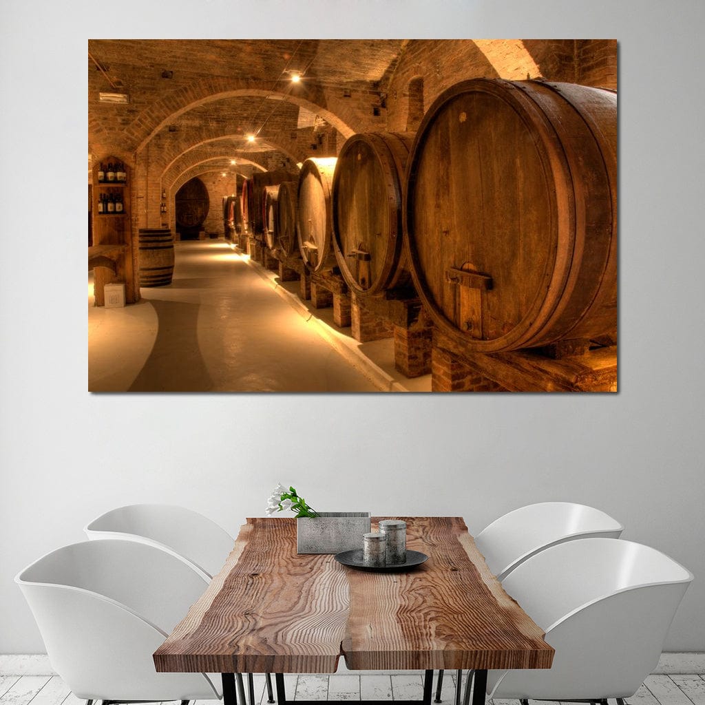 tablou canvas cu butoaie de vin, intr-un subteran in lumina calda, alaturi de sticle de vin si pereti de caramida