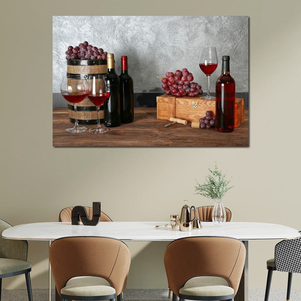 tablou canvas cu trei sticle de vin si pahare cu vin rosu pe o masa de lemn in stil rustic, alaturi de ciorchini de struguri