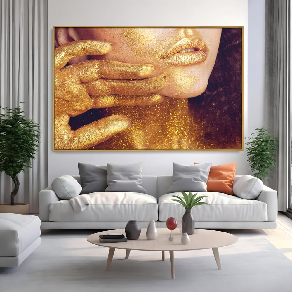 Tablou canvas cu tablou canvas cu portret feminin auriu, in rama de aluminiu auriu, pe perete intr-un living
