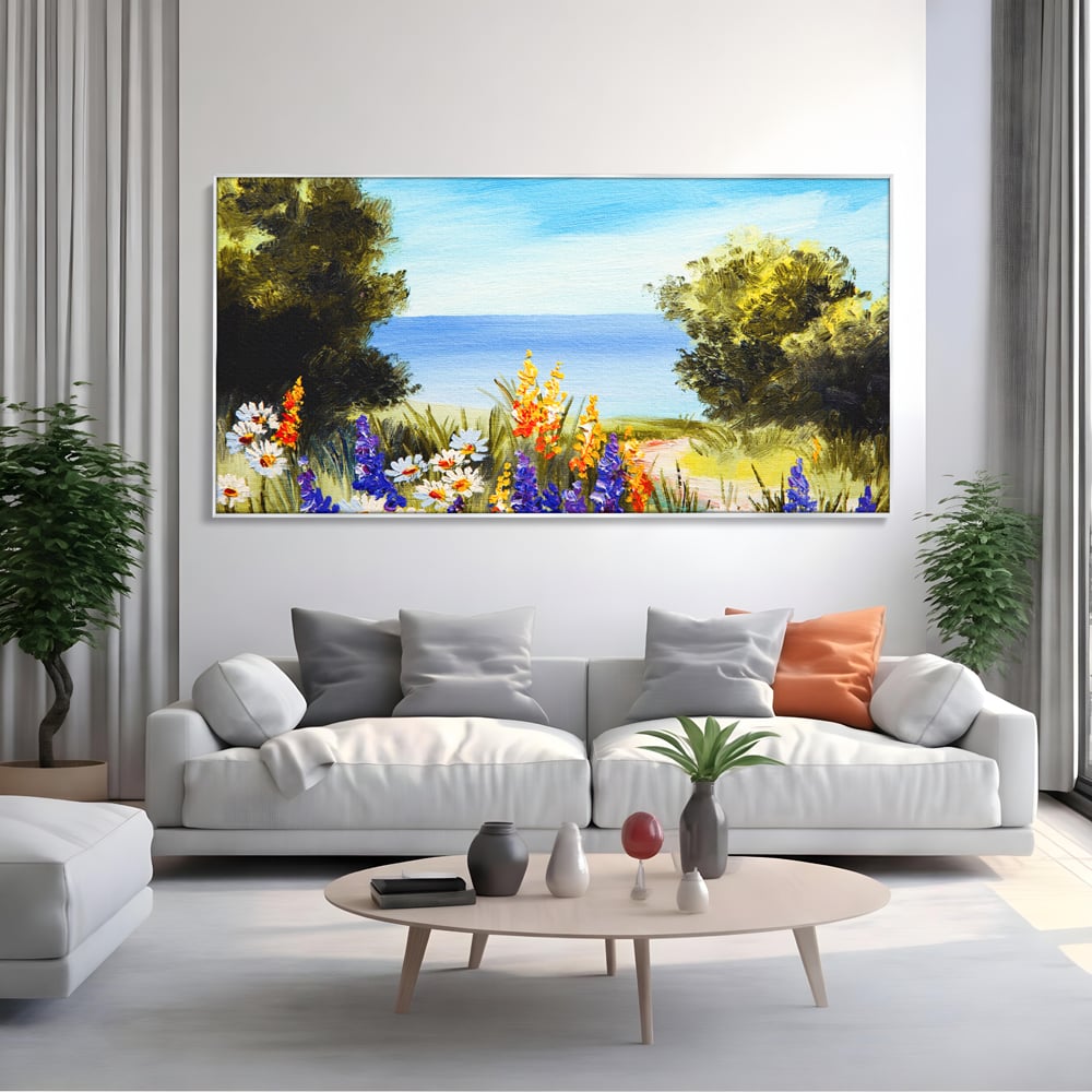 Tablou canvas cu tablou canvas cu peisaj marin si flori de camp, in rama de aluminiu argintiu, pe perete intr-un living
