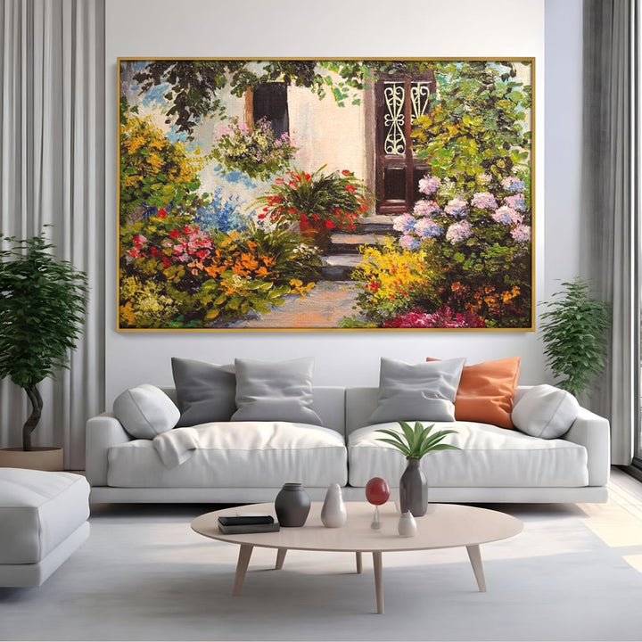 Tablou canvas cu tablou canvas cu alee florala si casa, in rama de aluminiu auriu, pe perete intr-un living