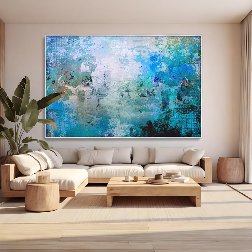 Tablou canvas cu pictura abstracta cu pete de albastru, in rama de aluminiu argintiu, pe perete intr-un living