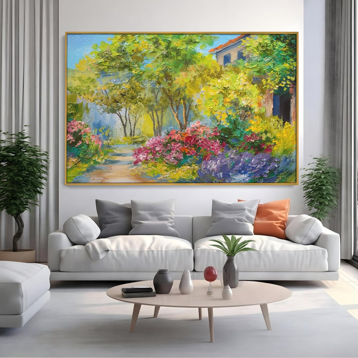 Tablou canvas cu tablou canvas cu peisaj de vara si flori, in rama de aluminiu auriu, pe perete intr-un living