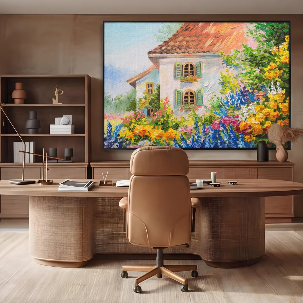 Tablou canvas cu pictura cu casa alba si flori, in rama de aluminiu negru, pe perete intr-un birou