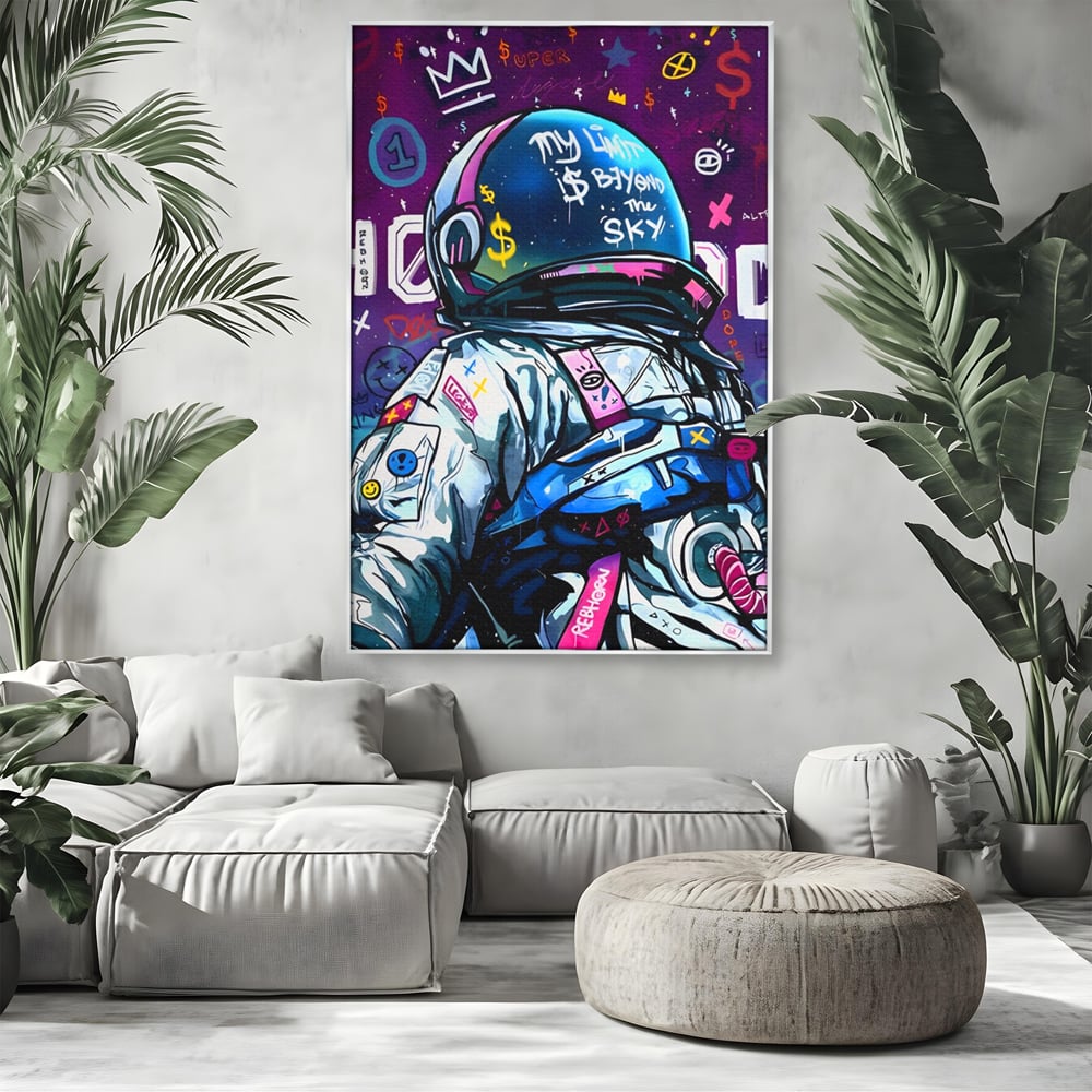 Tablou canvas cu tablou canvas cu astronaut graffiti, in rama de aluminiu argintiu, pe perete intr-un living