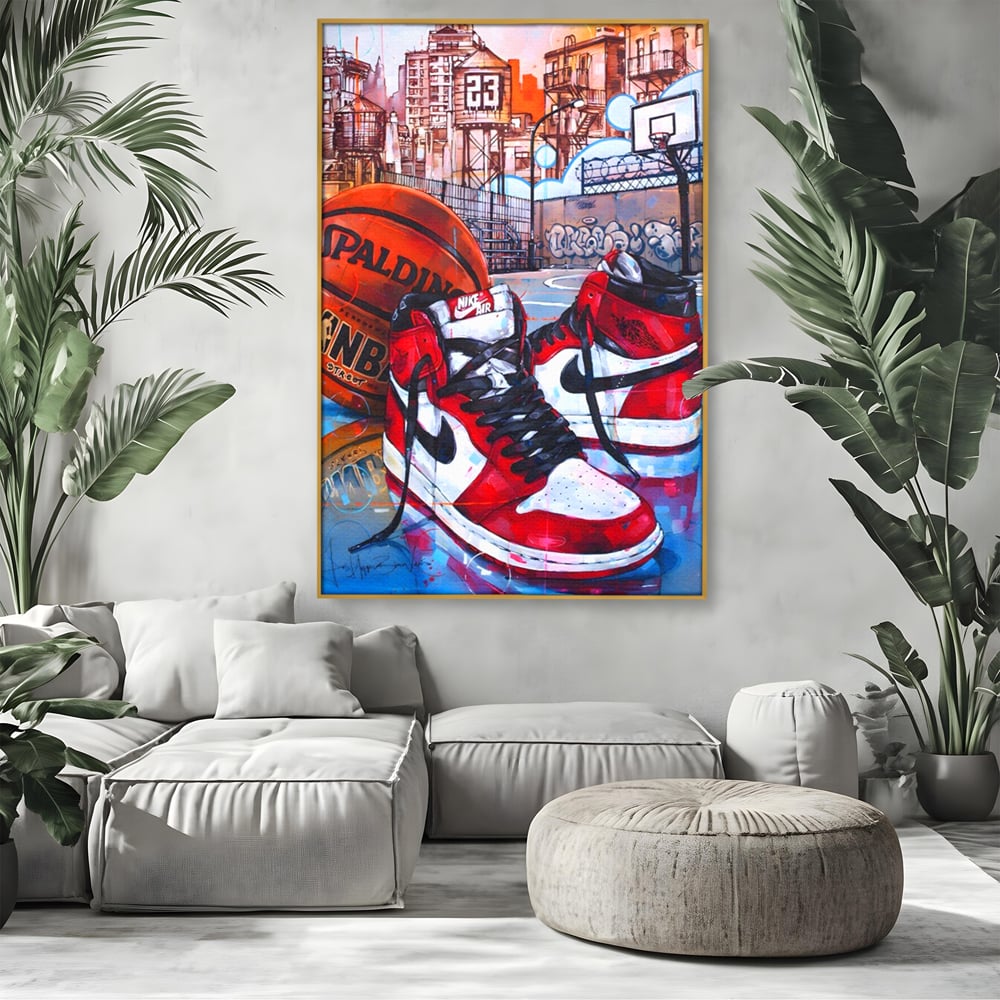 Tablou canvas cu tablou canvas cu adidasi si baschet, in rama de aluminiu auriu, pe perete intr-un living