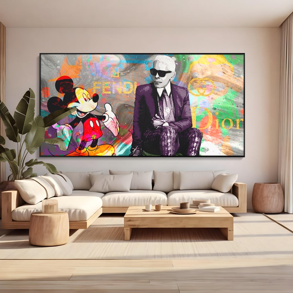 Tablou canvas cu tablou canvas cu mickey mouse si karl lagerfeld, in rama de aluminiu negru, pe perete intr-un living