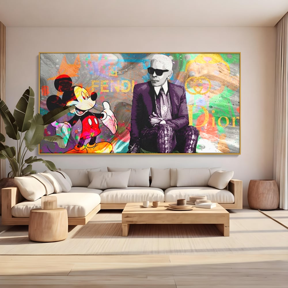 Tablou canvas cu tablou canvas cu mickey mouse si karl lagerfeld, in rama de aluminiu auriu, pe perete intr-un living