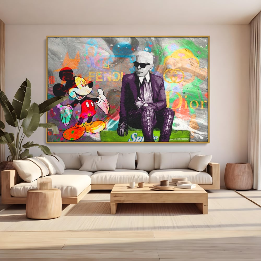 Tablou canvas cu tablou canvas cu mickey mouse si karl lagerfeld, in rama de aluminiu auriu, pe perete intr-un living