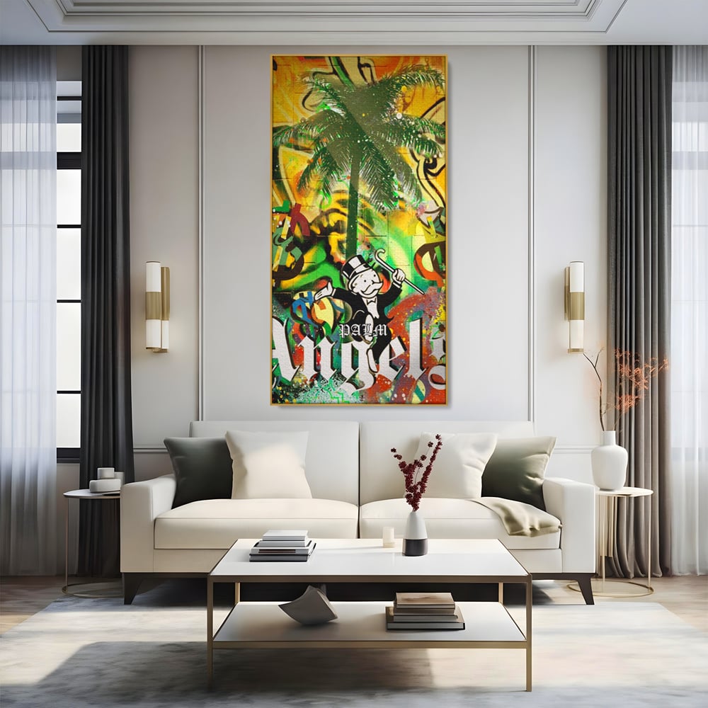 Tablou canvas cu tablou canvas cu graffiti monopoly si palmier, in rama de aluminiu auriu, pe perete intr-un living