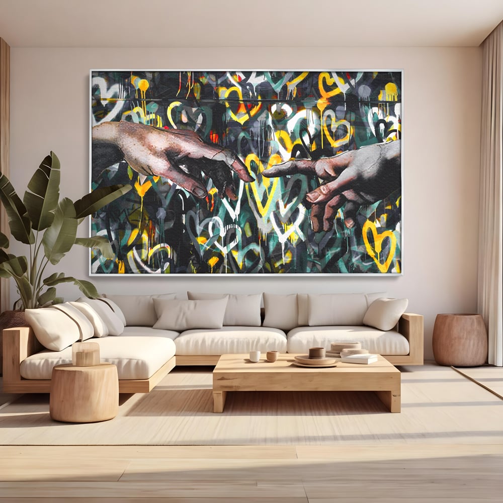 Tablou canvas cu tablou canvas cu maini si inimi, in rama de aluminiu argintiu, pe perete intr-un living