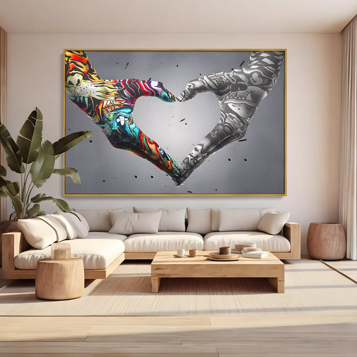 Tablou canvas cu tablou canvas cu maini in forma de inima stil grafitti, in rama de aluminiu auriu, pe perete intr-un living