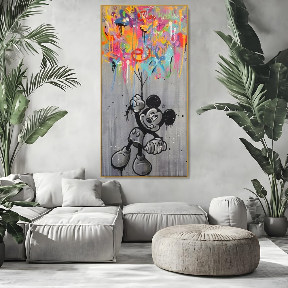 Tablou canvas cu tablou canvas cu mickey mouse si baloane, in rama de aluminiu auriu, pe perete intr-un living