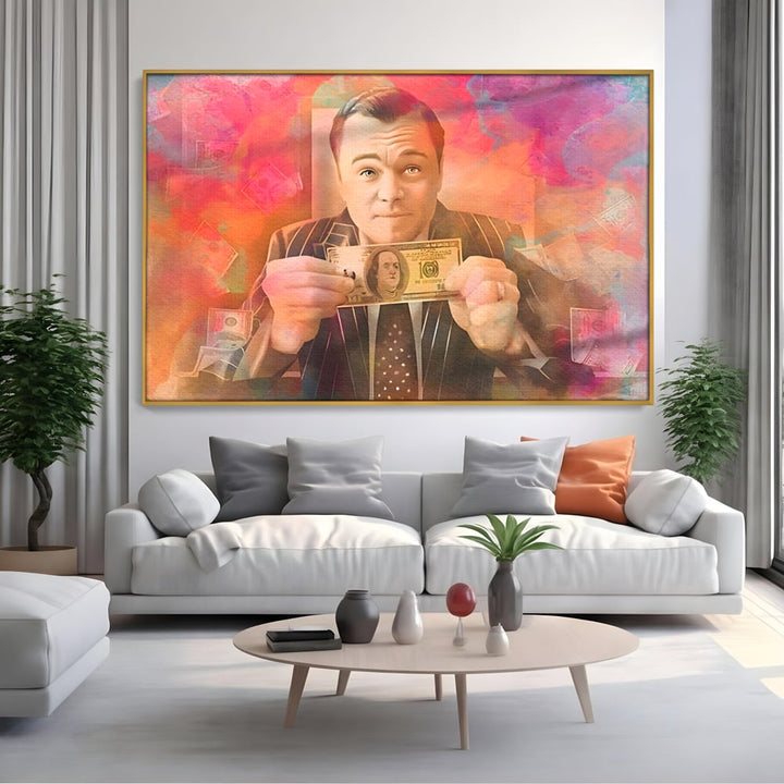 Tablou canvas cu tablou cu actorul leonardo dicaprio tinand bani, in rama de aluminiu auriu, pe perete intr-un living