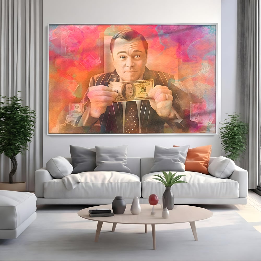 Tablou canvas cu tablou cu actorul leonardo dicaprio tinand bani, in rama de aluminiu argintiu, pe perete intr-un living