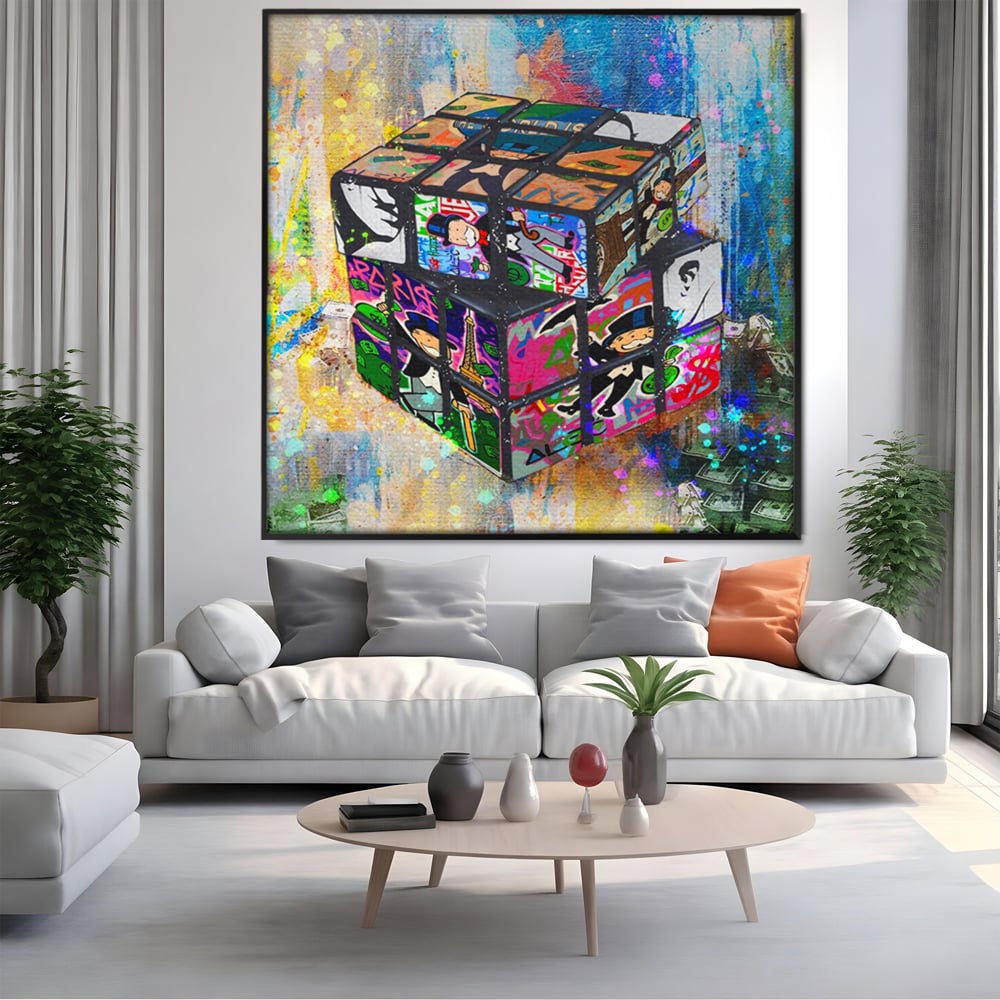 Tablou canvas cu pictura cub rubik cu monopol, in rama de aluminiu negru, pe perete intr-un living