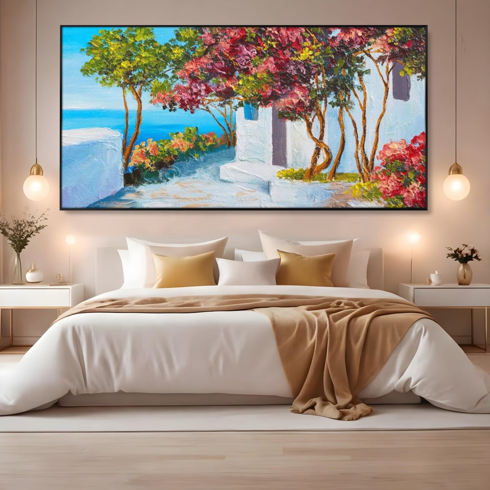 Tablou canvas cu pictura peisaj mediteranean cu flori roz, in rama de aluminiu negru, pe perete intr-un dormitor