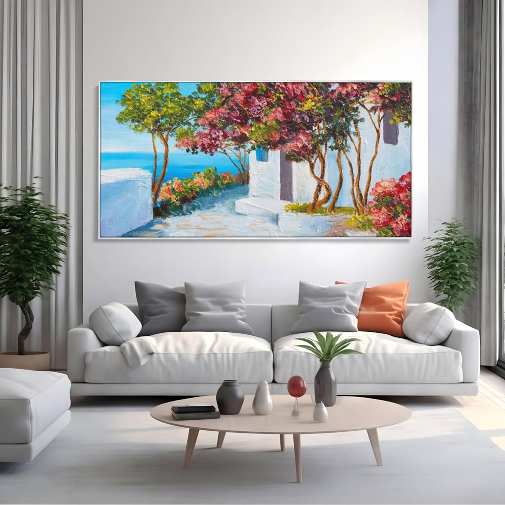 Tablou canvas cu pictura peisaj mediteranean cu flori roz, in rama de aluminiu argintiu, pe perete intr-un living