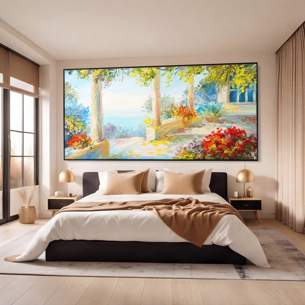 Tablou canvas cu pictura terasa insorita cu flori rosii, in rama de aluminiu negru, pe perete intr-un dormitor